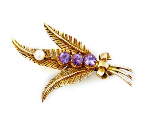 A Prince of Wales feather brooch, set with three amethyst stones and a single seed pearl, and bow to base, yellow metal, mark