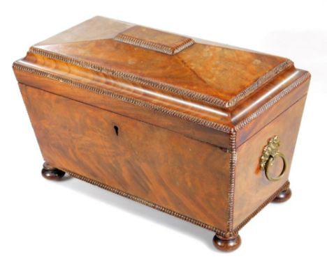 A Regency mahogany sarcophagus shaped tea caddy, with moulded outline and exterior gilt metal handles, the interior set with 