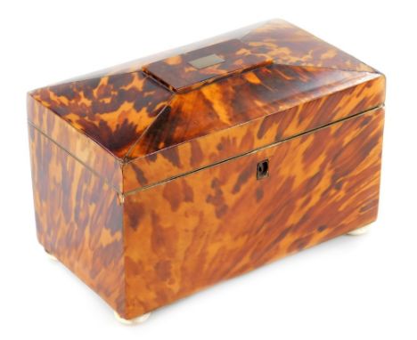 A Regency tortoiseshell tea caddy, with white metal cartouche, with a fitted part foil interior, raised on quadruple compress