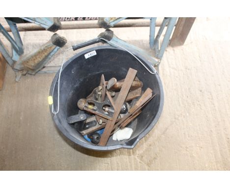 A plastic bucket with swing handles and contents of various tools to include smoothing plane, metal measures etc