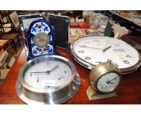 Two battery wall clocks, an alarm clock, a pottery cased clock, and a clock photo frame