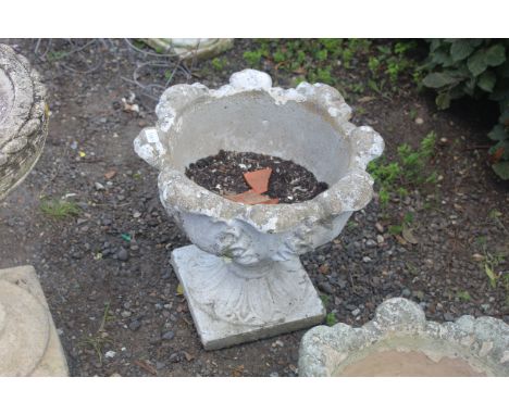 A painted concrete planter on raised base