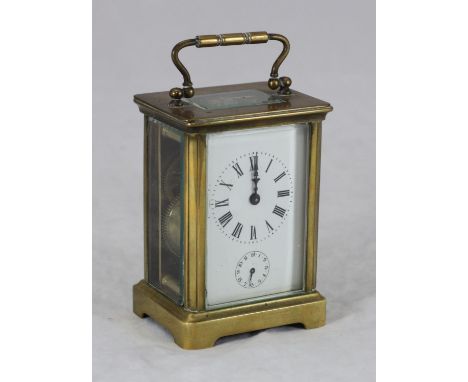 A brass carriage clock with alarm, the top with exposed platform escapement, above the white enamel dial Roman numerals denot