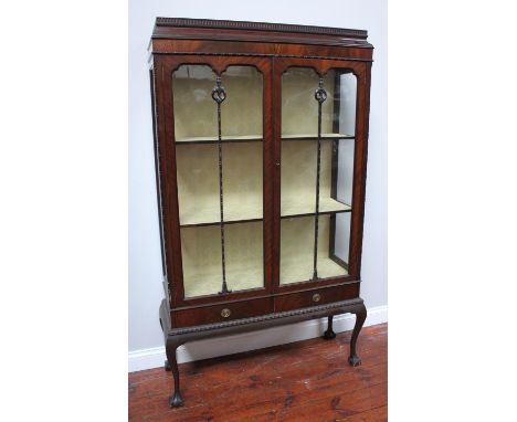 A stained mahogany two-door glazed display cabinet with dentil moulding, 3 shelves above a pair of drawers with brass ring pu