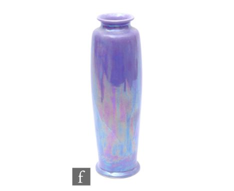 Ruskin Pottery - A large early 'Rolling Pin' vase of footed, swollen sleeve form, decorated with a deep purple lustre with fa