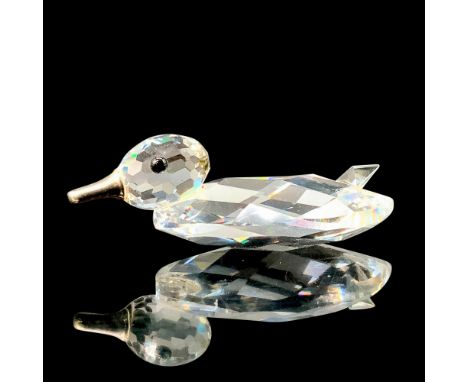 A clear crystal figure of a duck sitting down with black crystal used for the eyes and a metal bill. Swarovski backstamp. Thi