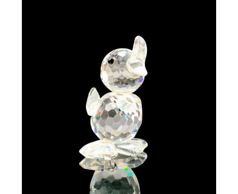 A clear crystal figure of a male duckling that is standing up with its wings raised and its bill open to quack. Black crystal