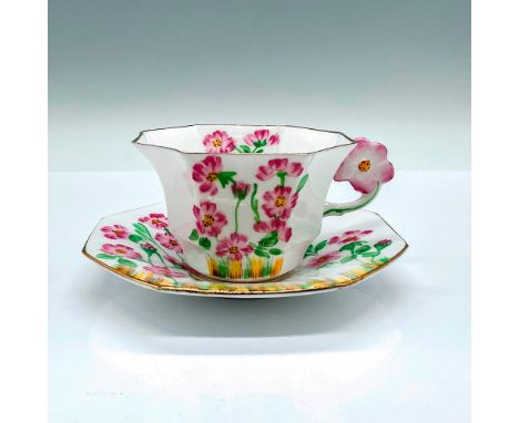 White cup and saucer set with gilt trims, adorned with pink flowers. Handle molded as a pink flower. Melba backstamp. Cup: 4.