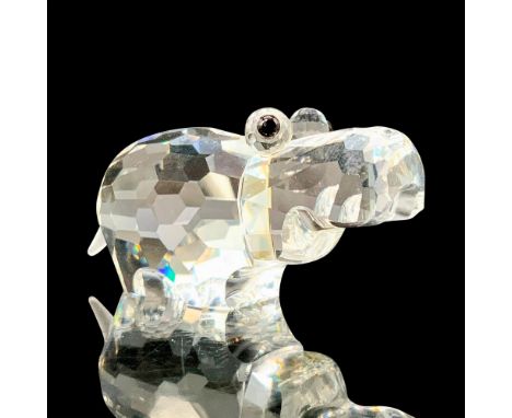A clear crystal figure of a hippo standing on all fours with black crystal used for the eyes and frosted crystal for the tail