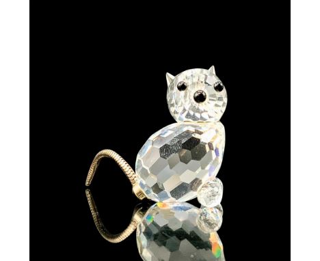 A clear crystal figure depicting a cat sitting down with black crystal used for the eyes and nose along with a metal tail. Sw