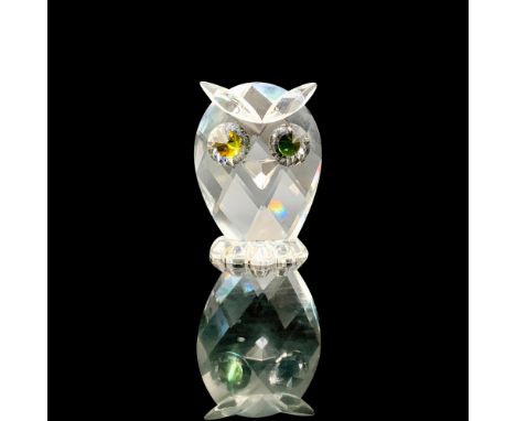 A clear crystal figure depicting an owl with melon-colored crystal used for the eyes. Swarovski backstamp. This item has its 