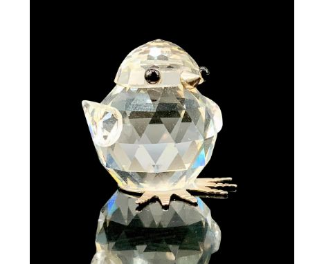 A clear crystal figure of a baby chick standing up with black crystal for the eyes and rhodium for the beak and feet. Swarovs