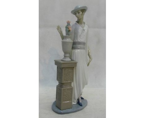 A Lladro lady standing by a pillar