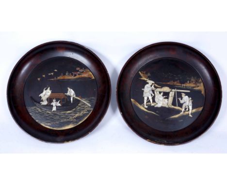 A PAIR OF JAPANESE LACQUERED CIRCULAR PLAQUES with mother of pearl decoration, 55cm diameter
