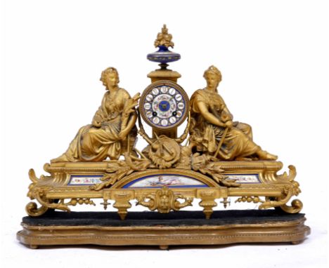 A 19TH CENTURY FRENCH GILT METAL CLOCK mounted with two figures and porcelain panels on a shaped stand 54cm wide x 41cm high