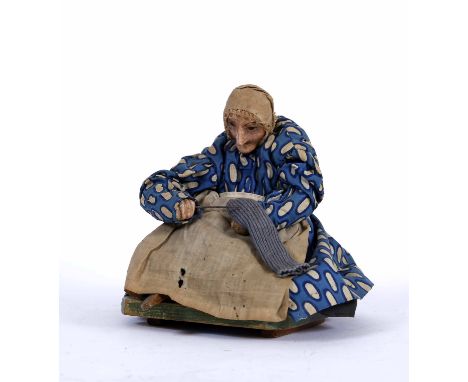 AN ANTIQUE, PROBABLY 19TH CENTURY, REPUTEDLY IRISH AUTOMATON, an old lady darning a sock, 15cm high 
