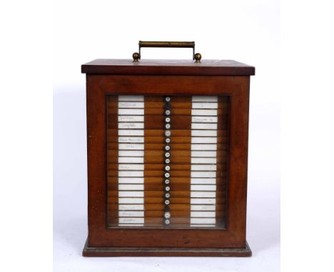 A MAHOGANY TABLE TOP MICROSCOPE SLIDE CABINET with glazed door enclosing twenty five shallow drawers with a label for Broadhu