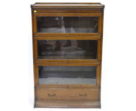 A GLOBE WERNICKE STYLE FOUR SECTIONAL OAK BOOKCASE with lower drawer, 86cm wide x 134cm high