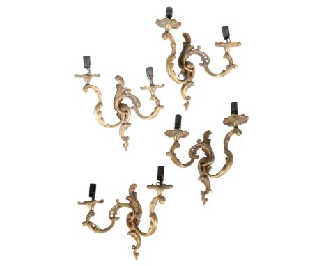 A SET OF FOUR GILT BRONZE TWIN LIGHT WALL APPLIQUES IN LOUIS XV STYLE, late 19th or early 20th century, the later electrical 