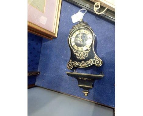 JAEGER; A MINIATURE BRACKET CLOCK, with a black case and brass overlay, with matching bracket, 17cm high (plus bracket)