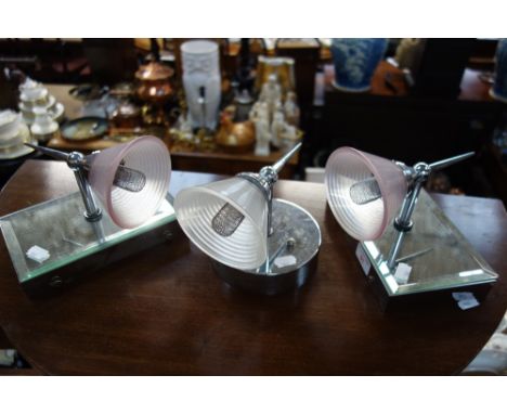 A PAIR OF CONTEMPORARY CHROME AND MIRRORED WALL LIGHT FITTINGS with glass shades and another similar example