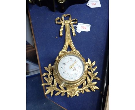 A FRENCH GILT BRASS WALL CLOCK, with swag decorated enamel face, 24cm high (replaced movement, now battery)