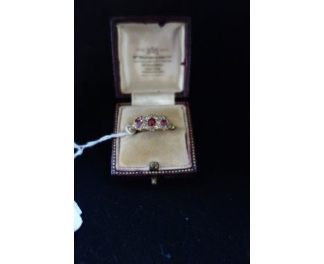 A TRIPLE 'RUBY' AND DIAMOND CLUSTER RING, (one diamond missing), on an 18ct yellow gold shank, ring size O