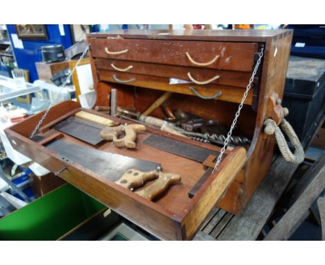A TEAK SHIPWRIGHT'S TOOL CHEST with fall-down front enclosing interior well and three drawers containing a variety of tools a