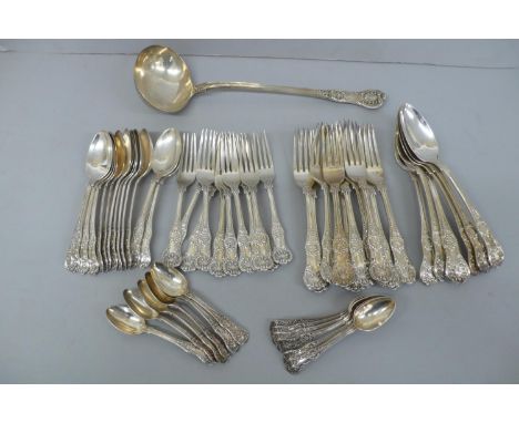 A set of Victorian Silver, fiddle, thread and shell pattern flatware consisting of 12 pudding spoons, 11 pudding forks, 12 ta