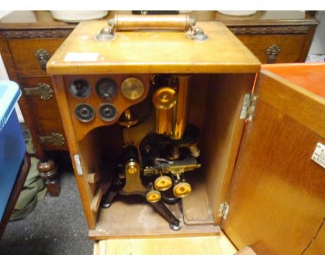 An early 20th century W. Watson & Sons Ltd lacquered brass microscope, Edinburgh model, with tripod base in a fitted mahogany