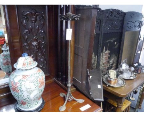 A wrought iron stand in the Arts and Crafts taste, surmounted by a shallow bowl within a leaf and scroll worked cup, on a tap