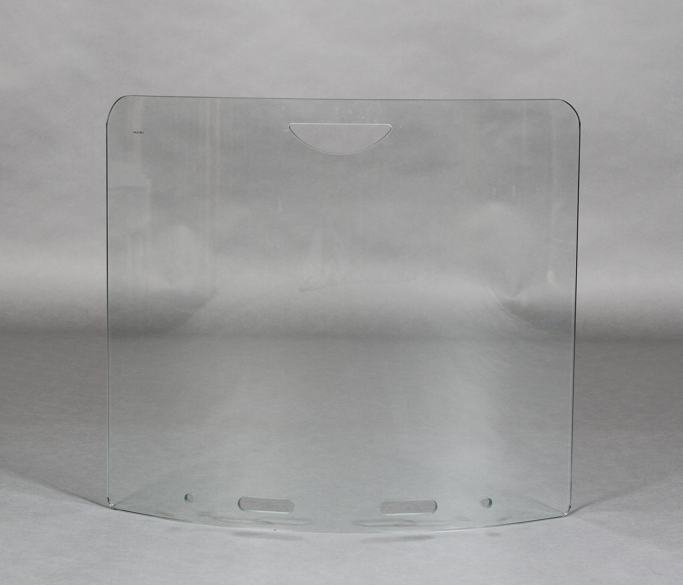 A glass fire screen, curved with finger grip, 67cm wide x 60cm high