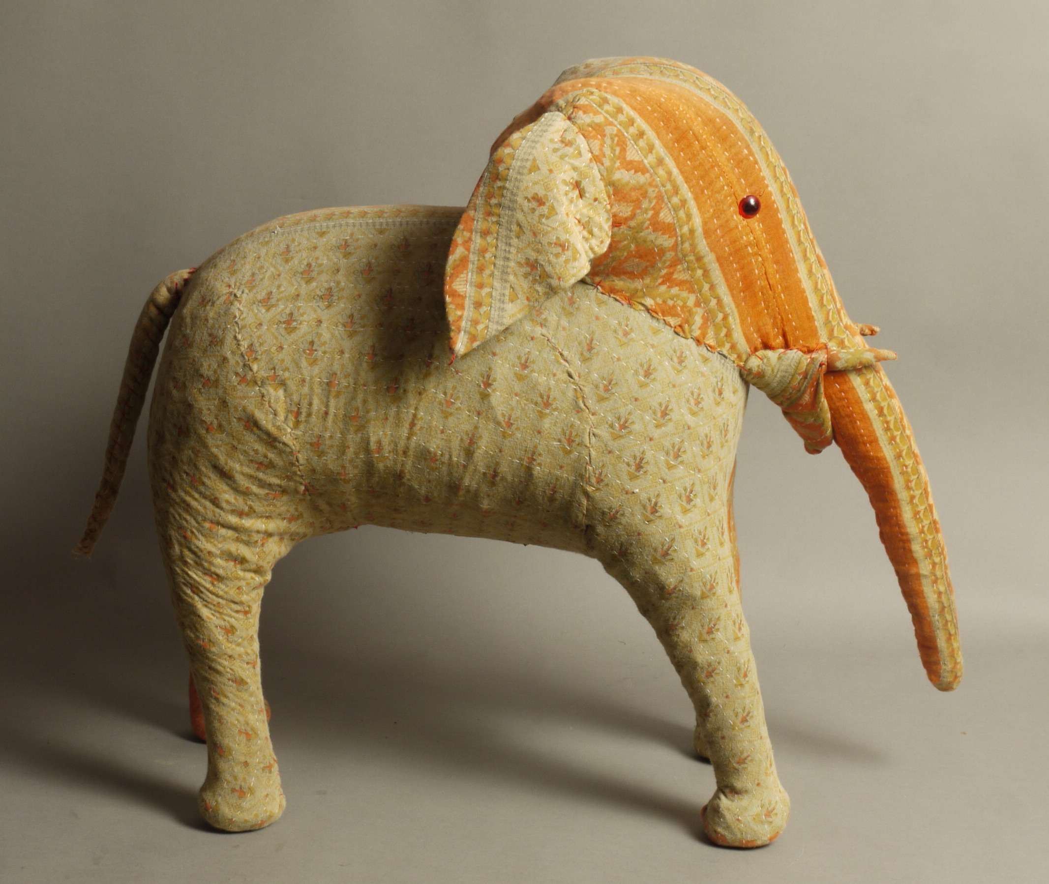 A straw filled elephant, covered in printed cotton approximately 55cm high