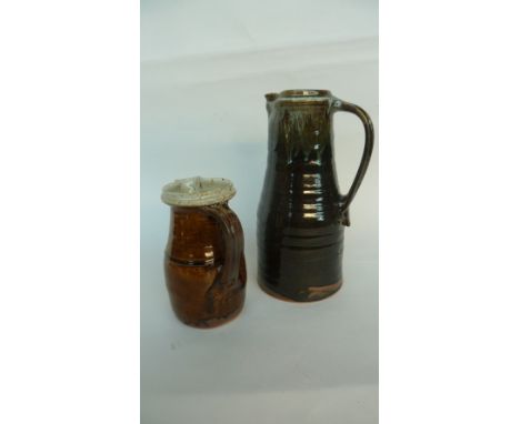 A large Mike Dodd stoneware jug with dark green glaze, marked MD at the lower rim, 34cm H together with a smaller jug with br