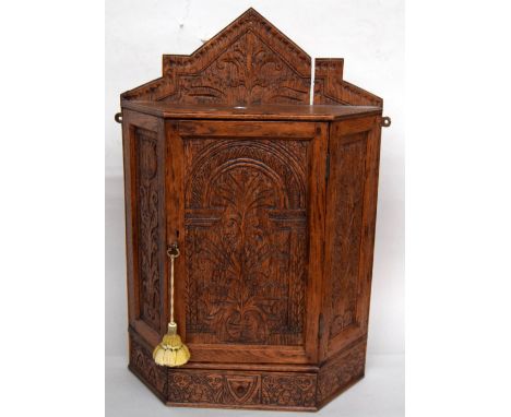 A 17th century style oak carved hanging cupboard with under shelf 48 x 68cm