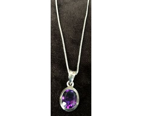 A sterling silver chain with a purple stone oval shaped pendant