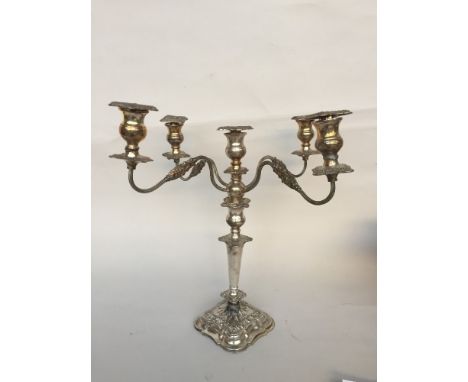 A candelabra with four reeded scrolled arms decorated with acanthus motifs which can be altered to a single candle stick on a