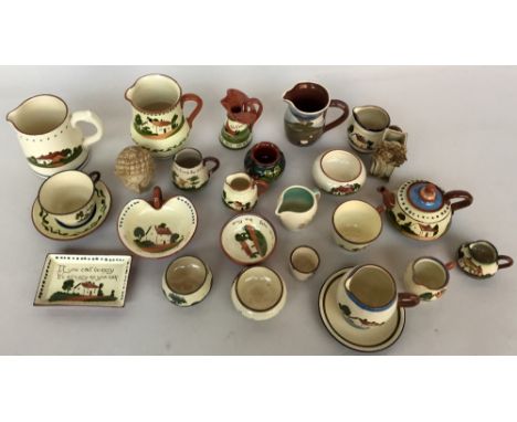 A selection of pieces of Watcombe Torquay Devon Pottery 'Mottoware' including jugs of various sizes, a small teapot, cups and