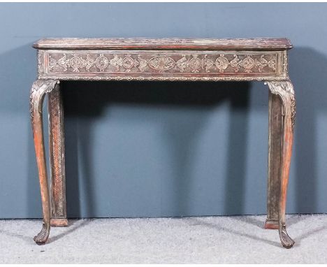 A silvered console table of "early 18th Century" design, with moulded edge to top, the top and frieze carved with paterae and