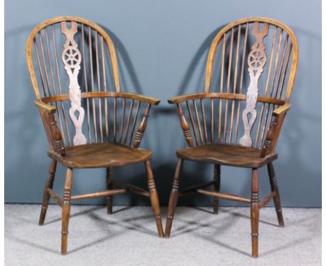 A pair of ash and elm seated wheel back Windsor armchairs with two tier stick backs, on turned underframes