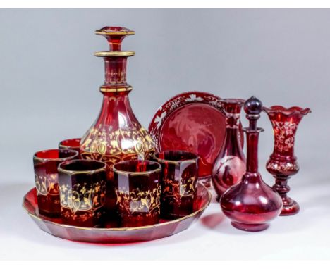 A 19th Century ruby tinted glass and gilt decorated drinks cabaret, comprising - mallet-shaped decanter and stopper with slic