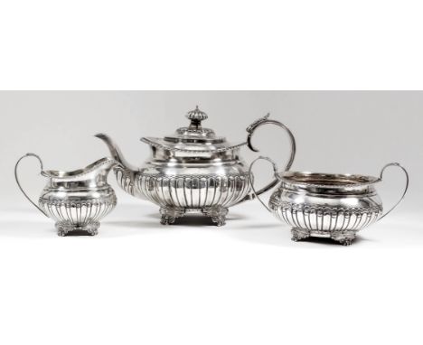 A George IV silver circular three piece tea service with gadroon mounts, part reeded and fluted bodies, leaf capped C-scroll 