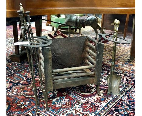 An antique cast iron and steel fire grate with swivel implement holders to each side and to/with an assortment of brass and s