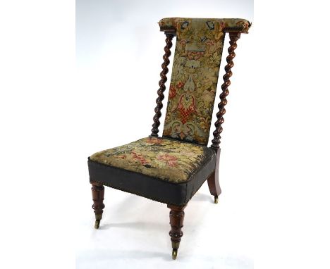 A Victorian walnut framed tapestry covered prie dieu chair, raised on brass castors