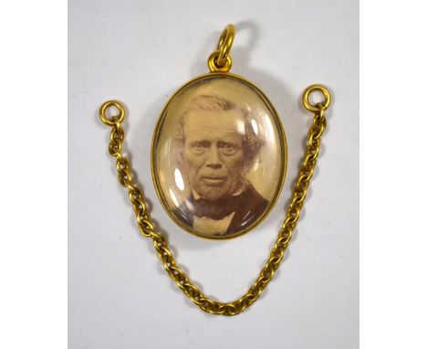 A Victorian oval crystal locket with yellow gold mount and hanger, containing photographs of man and woman within, 3.5 x 2.5 