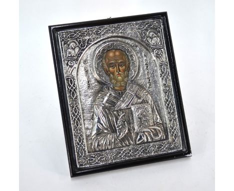 A Greek ship's icon with embossed white metal surround and painted face, St. Nicholas. Provenance - commercial ship the 'Delp