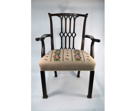 A George III mahogany framed open armchair in the Chippendale style, with overstuffed tapestry seat
