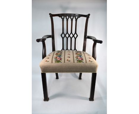 A George III mahogany framed open armchair in the Chippendale style, with overstuffed tapestry seat