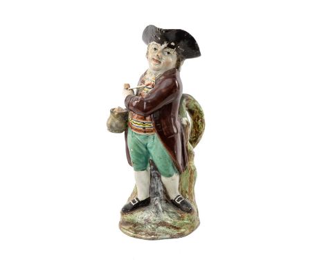 EARLY 19TH C. PEARLWARE 'HEARTY GOOD FELLOW' TOBY JUG, standing with twisted body, holding jug of ale and clay pipe, wearing 