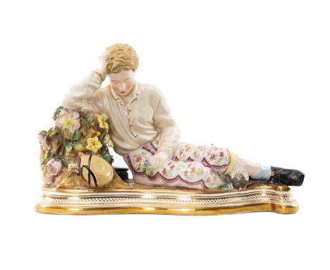 19TH c. JOHN BEVINGTON RECLINING CHINA FIGURE, of youth beside stump with book and flask, on shaped gilt base, blue printed m